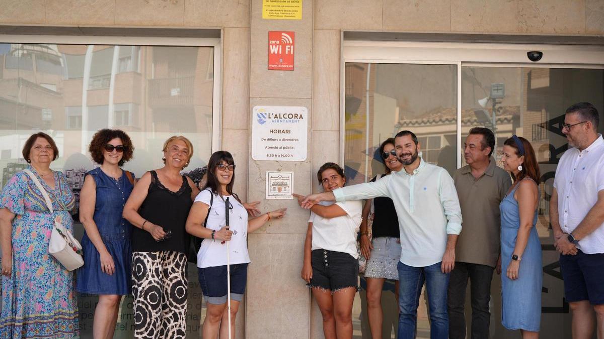 Foto con el pictograma cerámico instalado en el exterior del ayuntamiento, con el alcalde Falomir, la edila Huguet, representantes educativos y vecinas colaboradoras del proyecto.