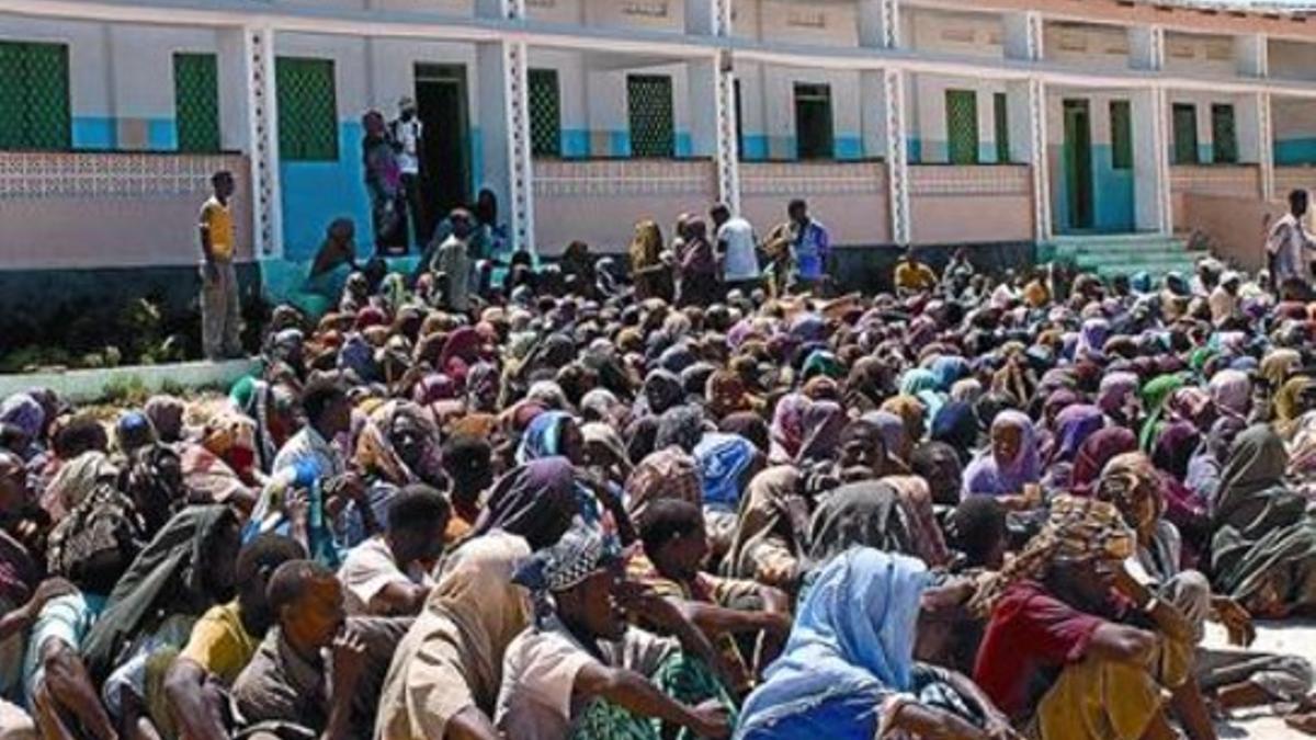 Desplazados somalís esperan una ración de comida en Mogadischo.