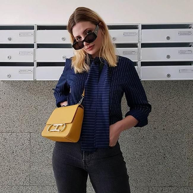 Miriam Giovanello con camisa azul y bolso amarillo