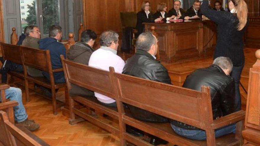 Los siete acusados en el momento de aceptar las penas ayer en la Audiencia Provincial.  // Rafa Vázquez