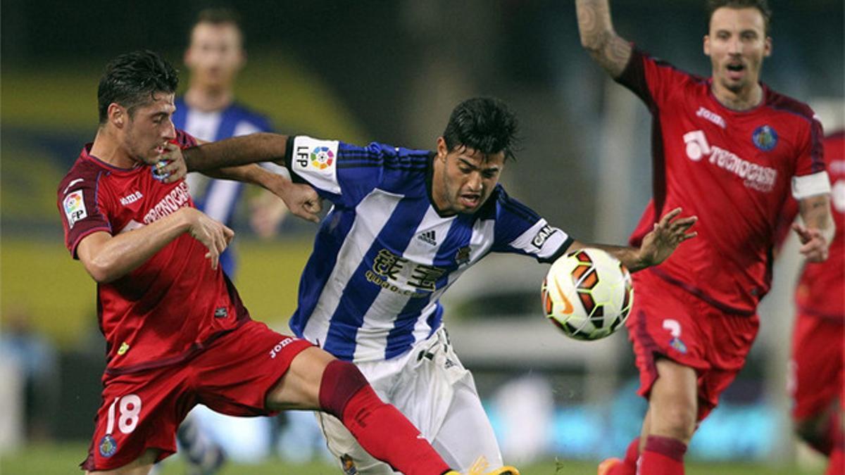 Carlos Vela intenta superar la entrada de Escudero durante el encuentro del lunes en Anoeta