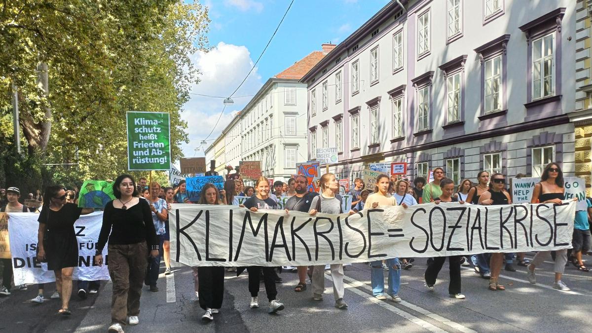 Österreich, Graz: Klimaaktivisten tragen ein Banner mit der Aufschrift &quot;Klimakrise = Sozialkrise&quot;.