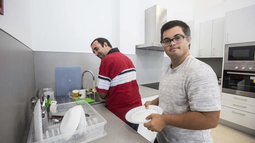 Dos de los usuarios hacen prácticas en la cocina con la que está equipado el centro de día.