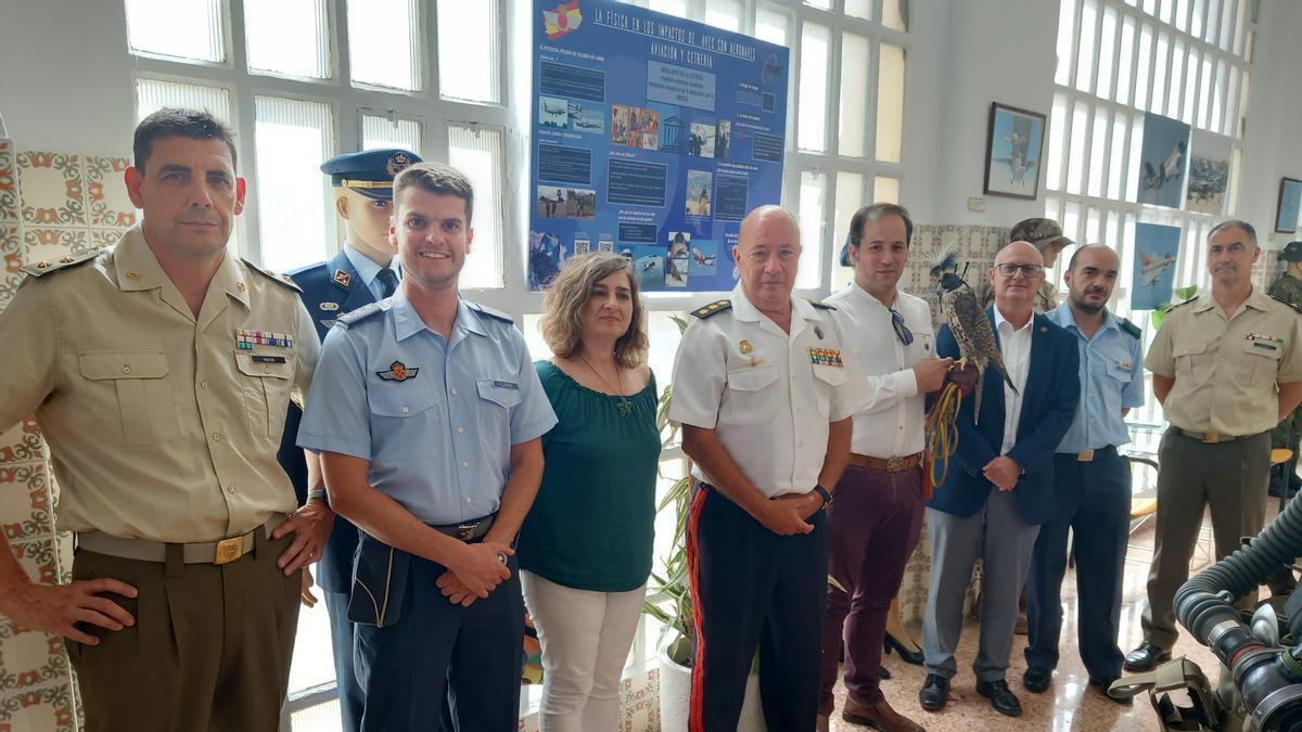 Los asistentes al acto junto al carterl instalado en la exposición de la Subdelegación de Defensa en Alicante.