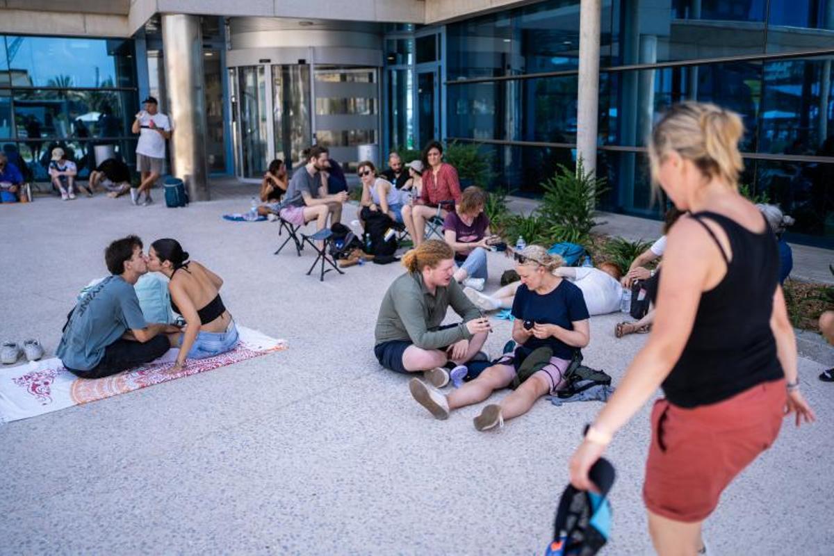 Visitantes y aficionados a la observación astronómica esperan en el Port de la Maria, en Tarragona, para contemplar el eclipse total de Sol.