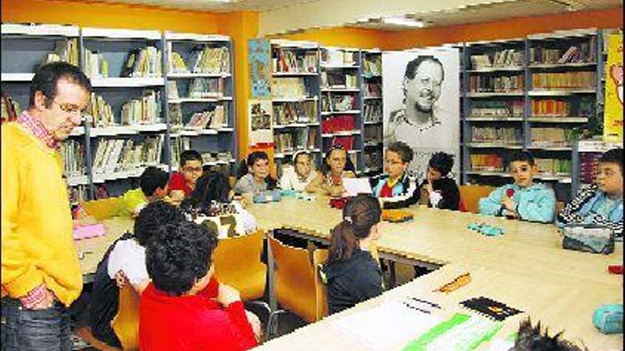 Javier Cellino y los alumos del Eulalia Álvarez hablan de poesía, presididos por un retrato de Alberto Vega.