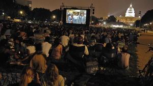 Ciclo de cine con el Capitolio de fondo, pantalla gigante y cinéfilos sobre césped.