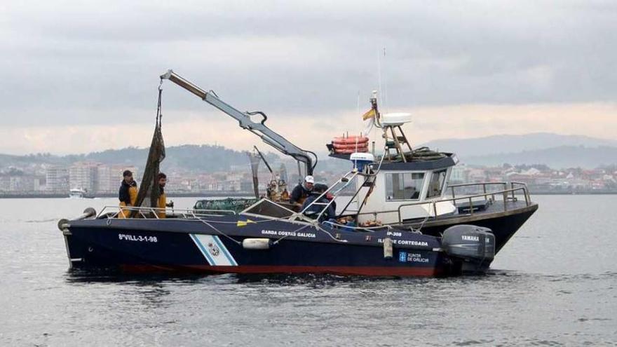 Personal de Gardacostas solicita la documentación de un barco en una ría gallega.