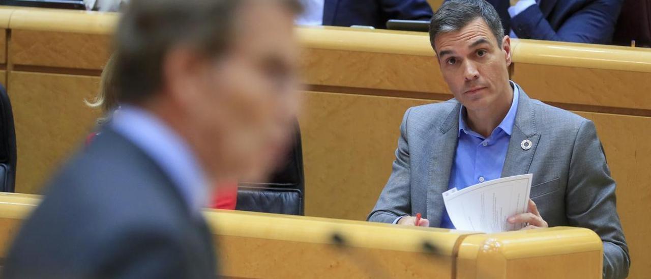 El presidente del Gobierno, Pedro Sánchez, escucha la intervención del líder del PP, Alberto Núñez Feijóo.
