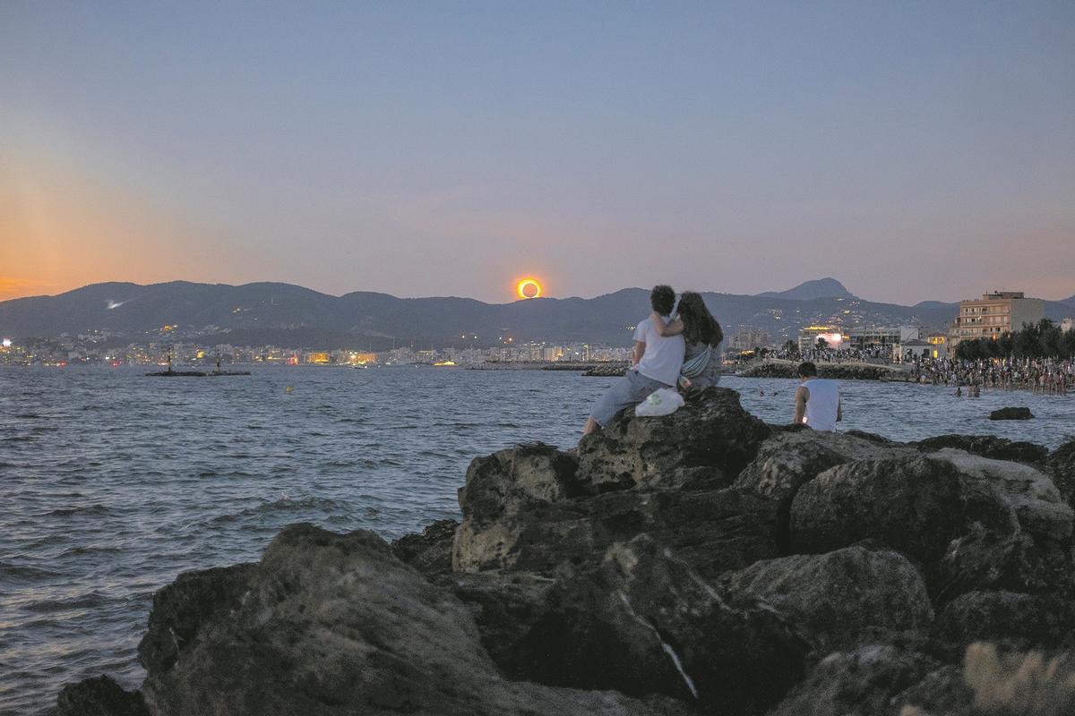 Una pareja disfruta del eclipse en el Molinar.
