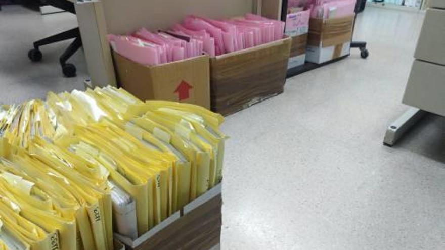 A la izquierda y sobre estas líneas, cajas de expedientes por los suelos en los juzgados de Gandia.