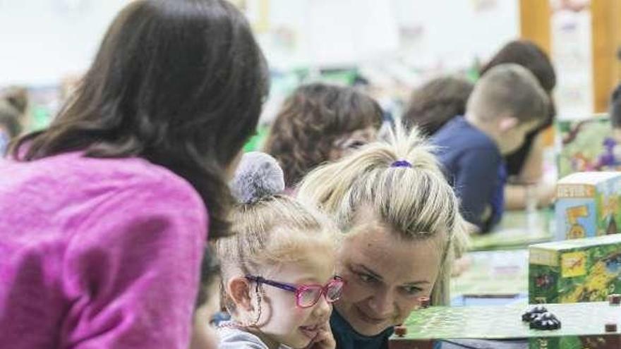 Alumnos del colegio Versalles, con familiares y monitores, durante el taller de juegos de mesa celebrado ayer en el centro educativo.