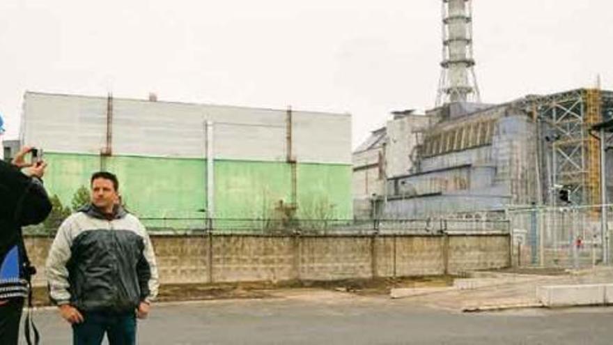 Desde 2002 la zona de exclusión de Chernobil se ha convertido en destino turístico para los curiosos. En la imagen, un hombre posa delante del sarcófago que protege el reactor. / reuters