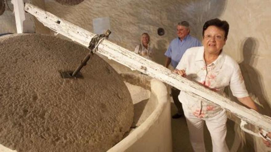 Luisa Pastor haciendo girar el molino más antiguo que se conserva en la antigua Almàssera dels Assegadors.