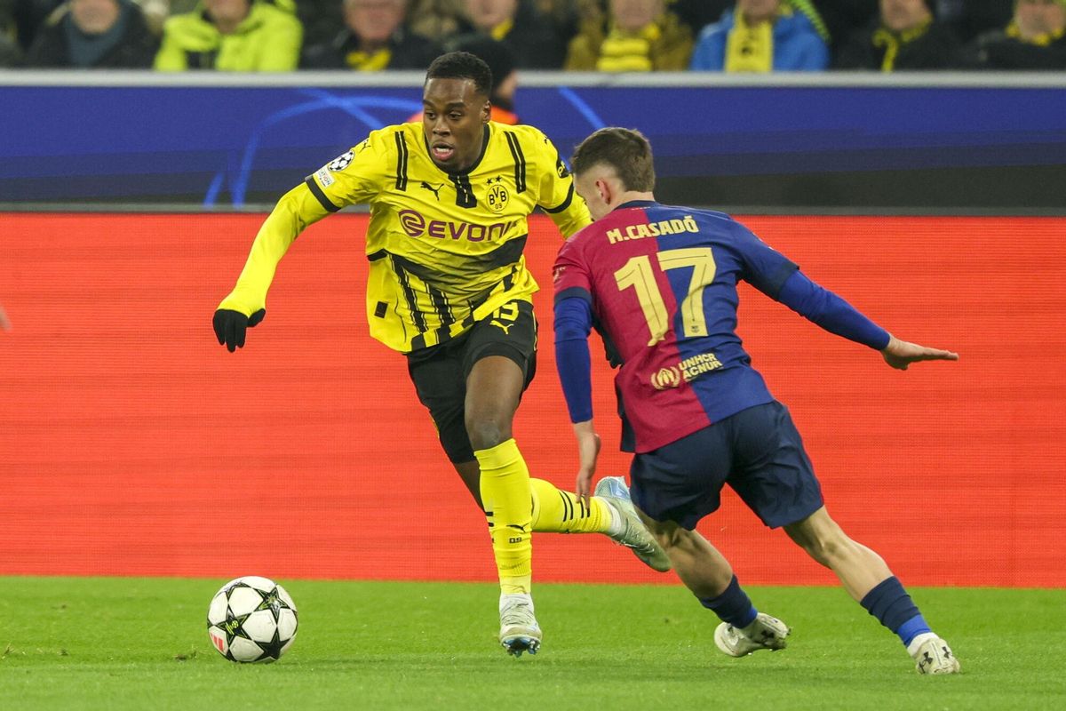El jugador del Dortmund Jamie Gittens (I) en acción ante Marc Casado (d) durante el partido de la UEFA Champions League que han jugado Borussia Dortmund y FC Barcelona en Dortmund, Alemania.EFE/EPA/FRIEDEMANN VOGEL. borussia dortmund . barça. liga campeones 2024/2025 borussia dortmund . barça. 06. accion. signal iduna park