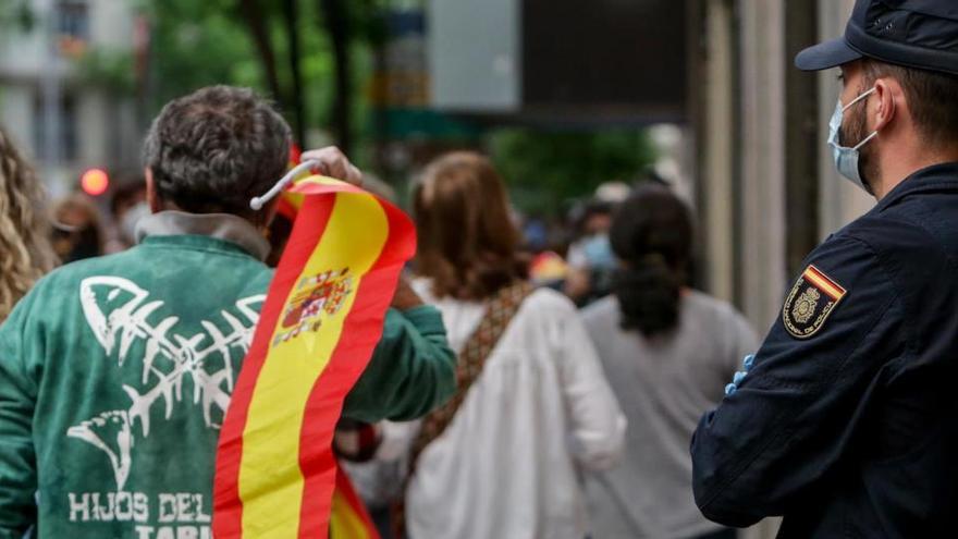 Un hombre con una bandera de España durante la cacerolada.