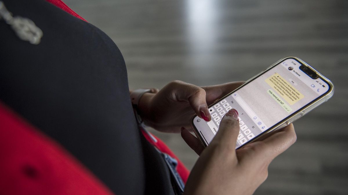 Joven enviando un WhatsApp a su madre en lugar de llamarla por teléfono.