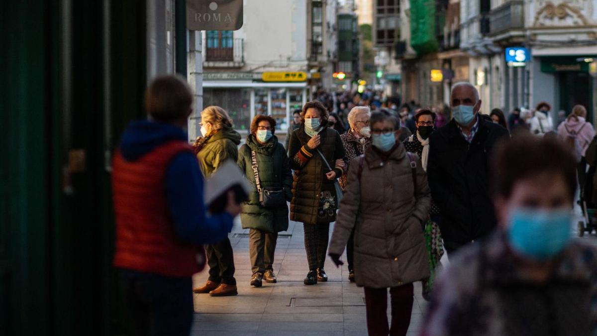 Un grupo de personas, con mascarilla, en la calle Santa Clara. |