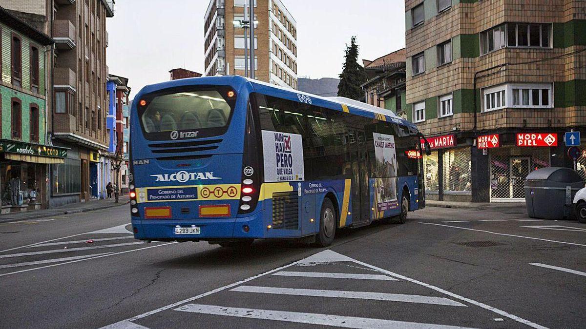 Viajeros tomando el autobús urbano del valle del Nalón en La Felguera.