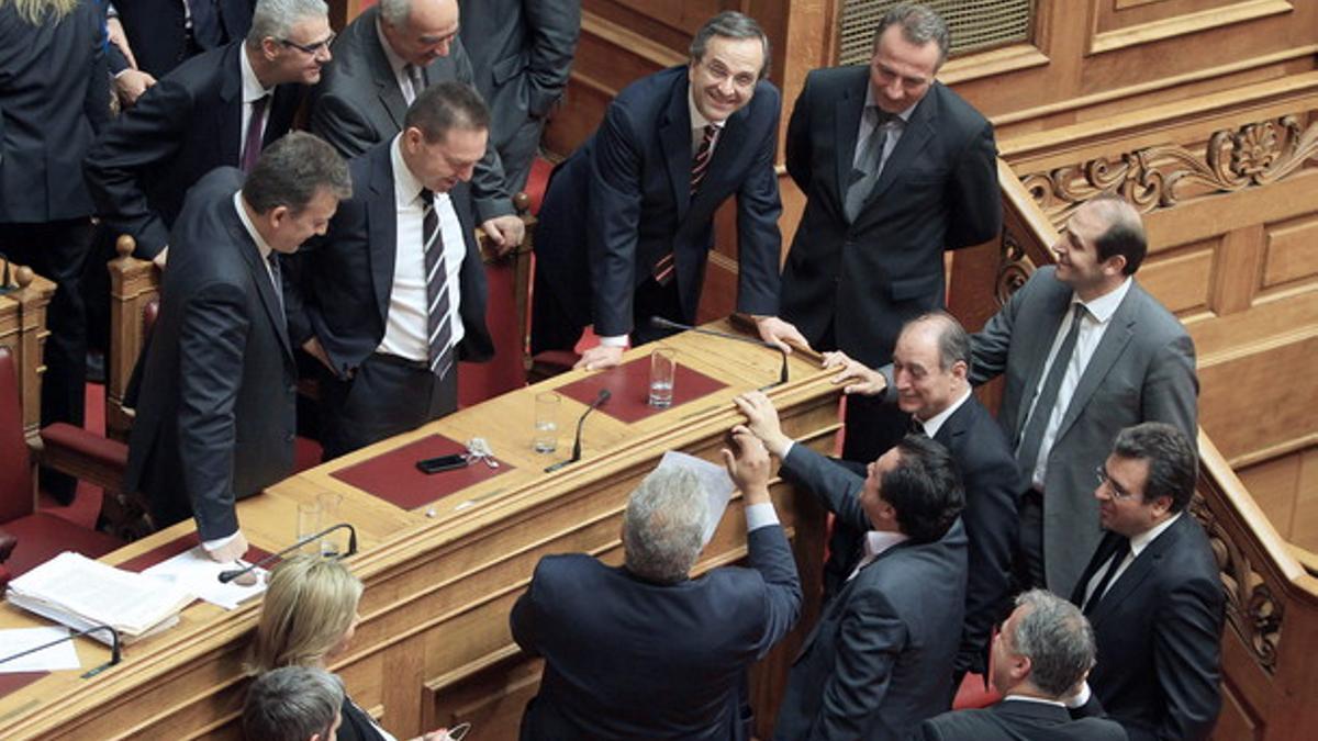 El primer ministro griego, Andoni Samarás (en el centro, apoyado en la mesa) este sábado, en el Parlamento griego.