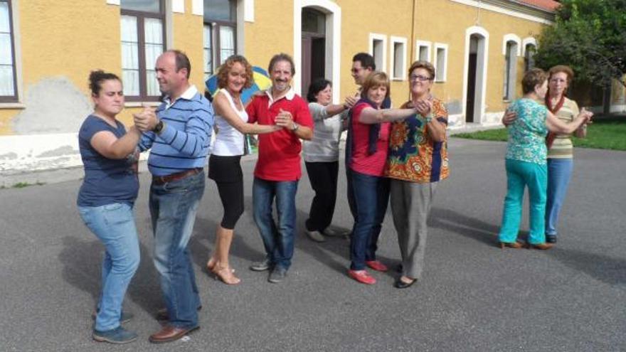 Vecinos de Logrezana, ayer, bailando en el exterior de las escuelas rurales.