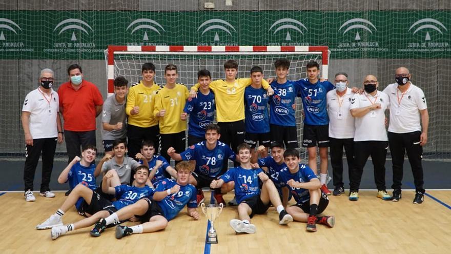 Los jugadores y técnicos del Cajasur Córdoba Balonmano cadete en la sala de Valdeolleros con el trofeo de campeones.