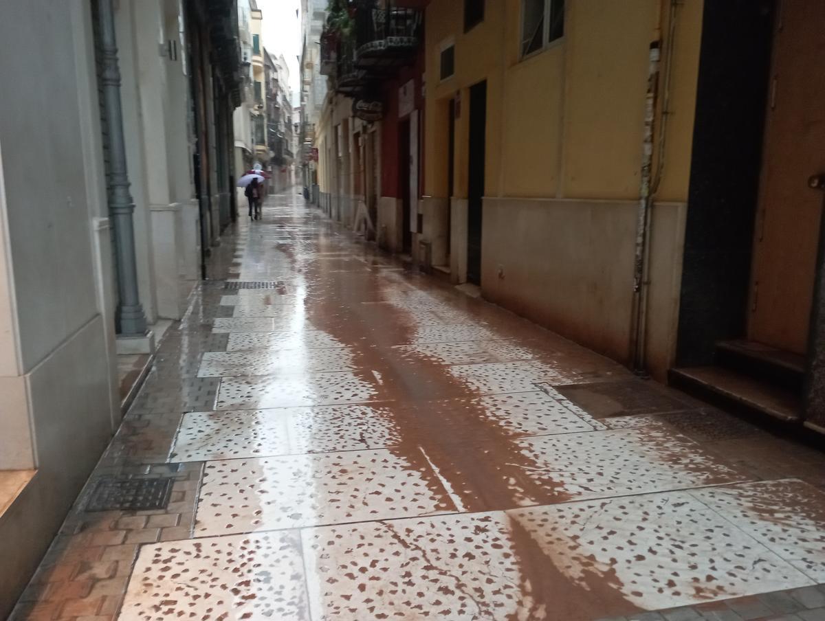 El barro de la calima evidenció los grandes charcos en la semihundida, resbaladiza y horadada calle Santa María.