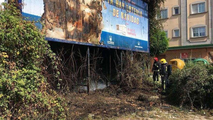 Los bomberos sofocan las llamas en los matorrales en esta finca de Mollavao. // Rafa Vázquez