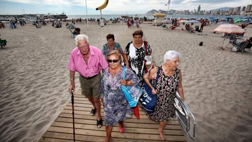 Un grupo de turistas de la tercera edad, abandonando la playa de Poniente, en una imagen tomada a mediados de noviembre.