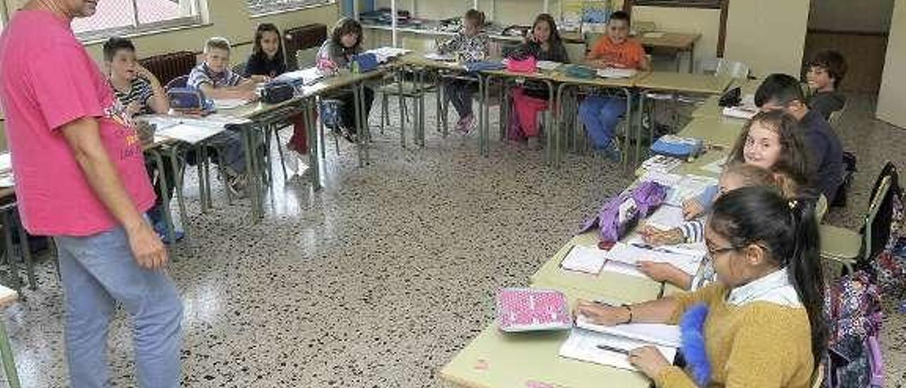 A la izquierda, Rufino Sánchez imparte clase en asturiano en el colegio El Bosquín. A la derecha, alumnos del colegio de La Carriona en un taller de asturiano, el curso pasado.