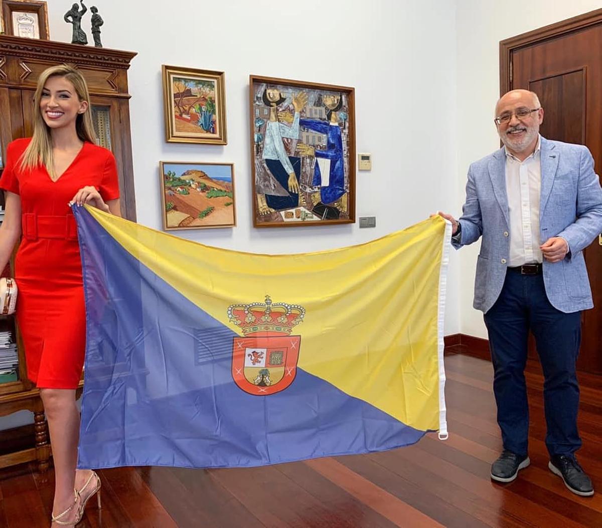 Carla Benítez y el presidente del Cabildo de Gran Canaria, Antonio Morales, posan con la bandera insular antes de que la joven fuera a Miss World Spain