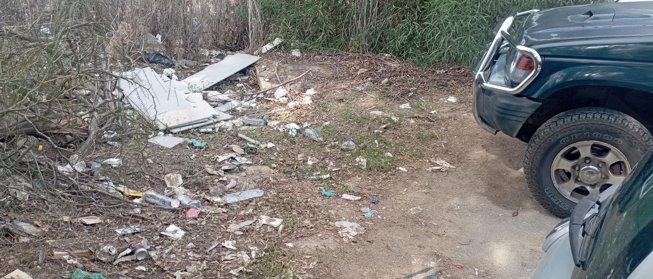 Detalle de basuras varias la semana pasada, al pie de los coches junto al aparcamiento en un lateral del Clínico.