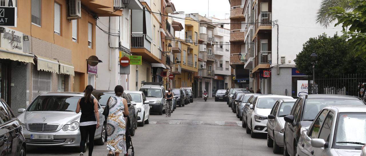 Una calle de Benigànim con coches aparcados a ambos lados de la vía.