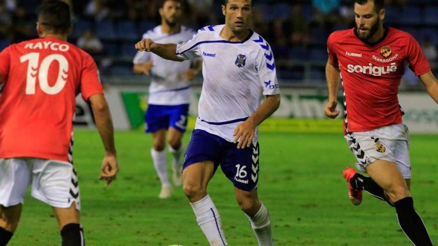 Aitor Sanz lleva el balón con la camiseta del Tenerife, entre dos contrarios del Nàstic.
