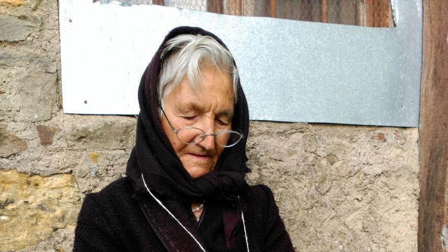 La Tí Prisca teje a la puerta de su casa, en Mahíde.