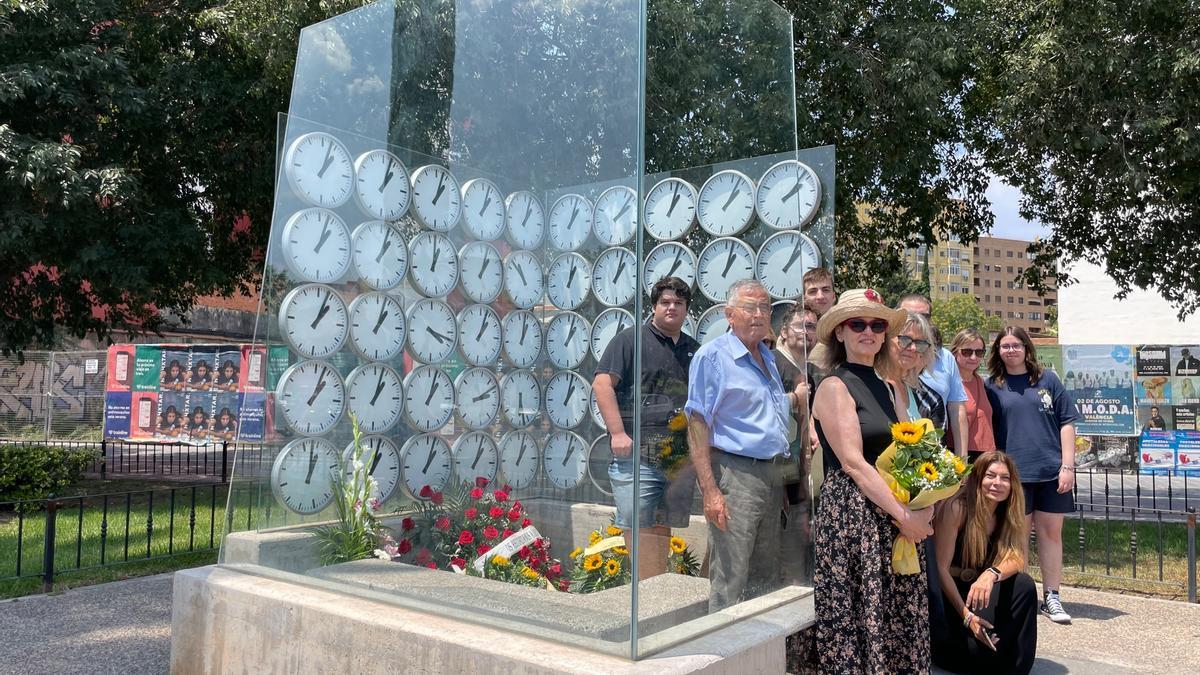 Las familias que han acudido a depositar flores en recuerdo de sus seres queridos al monumento memorial de la artista Anja Krakowski sobre la curva del accidente.