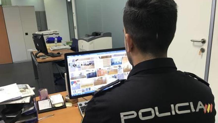 Un policía consultando información de las vivendas en internet.