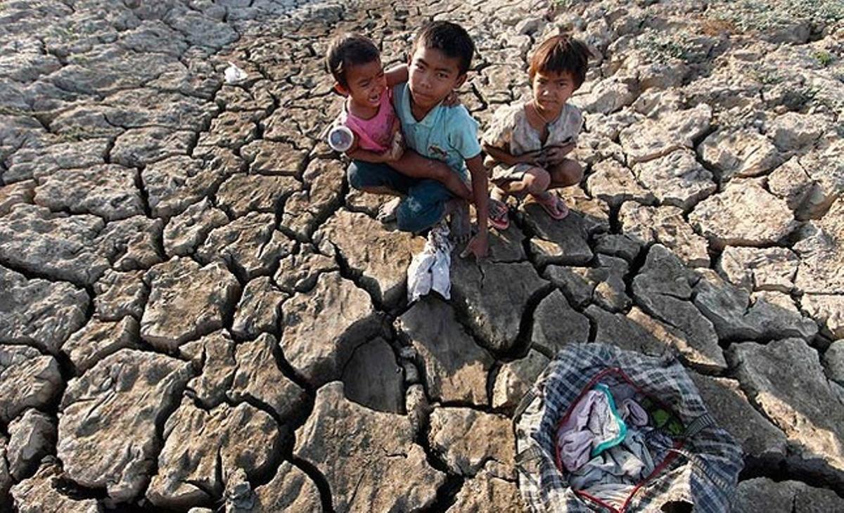 Nens de barris marginals recullen roba vella en un llac sec, als afores de Yangon (Myanmar).