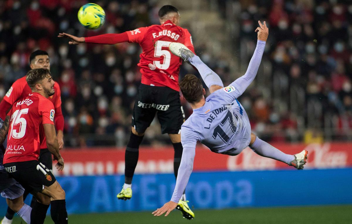 El delantero holandés del Barcelona, Luuk de Jong, patea el balón junto al defensor argentino del Real Mallorca, Franco Russo.