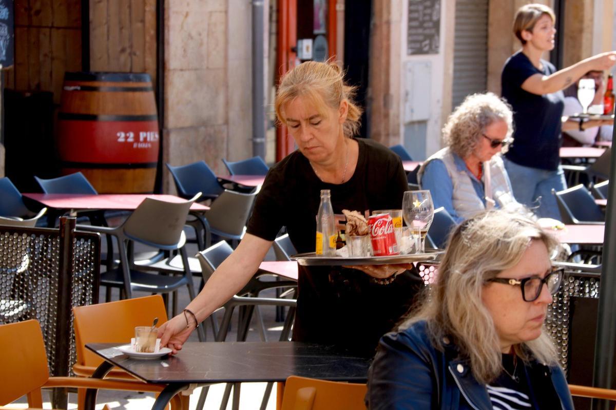 Una cambrera treballant en una terrassa d'un bar, en una imatge d'arxiu.