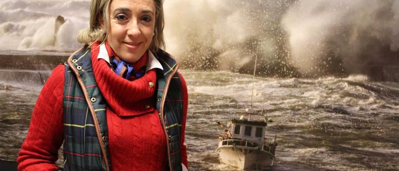 Isabel Cuervo, delante de una foto de un temporal azotando la costa de Tapia.