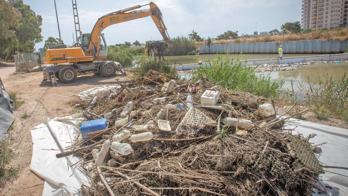 Retirada de envases, la mayor parte de plástico y de bardomeras vegetales en la barrera de contención de la desembocadura del Segura, que suele llenarse solo días después de su limpieza