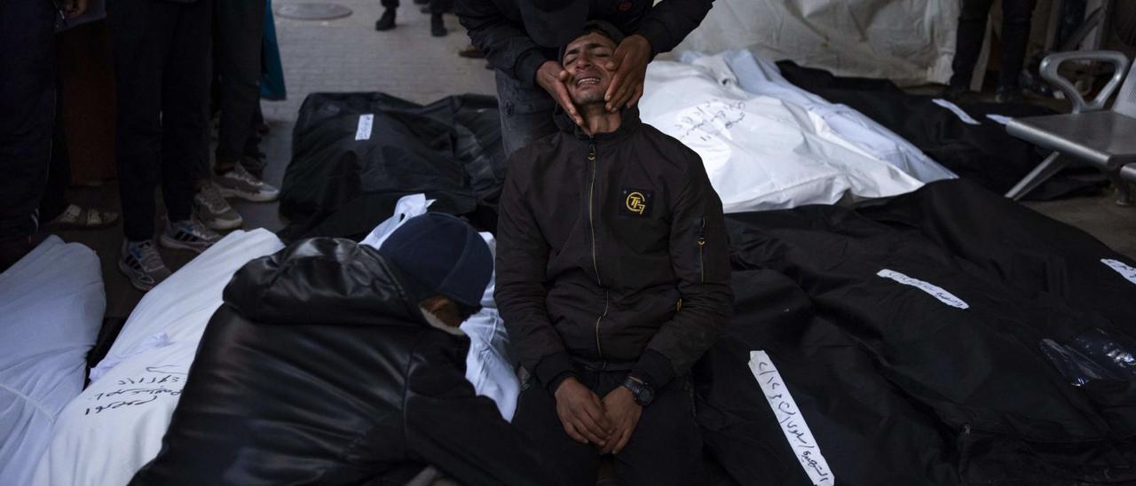 Uns palestins ploren al costat dels cadàvers de familiars morts per un bombardeig israelià a Rafah, dilluns. | FÀTIMA SHBAIR / AP