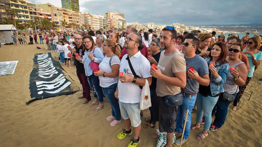 SOS y velas en Las Canteras por los refugiados