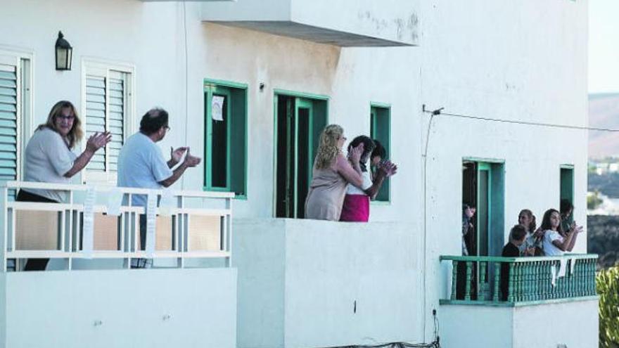 Inquilinos en un edificio de Arrecife, en Lanzarote, aplauden como cada tarde a las siete a quienes están cuidando de los enfermos en los hospitales.
