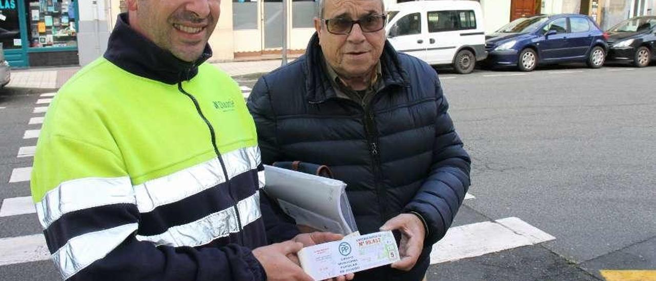 Enrique José Fernández y Eduardo Arias, ayer, con el talonario, en la avenida de Galicia de Luarca.