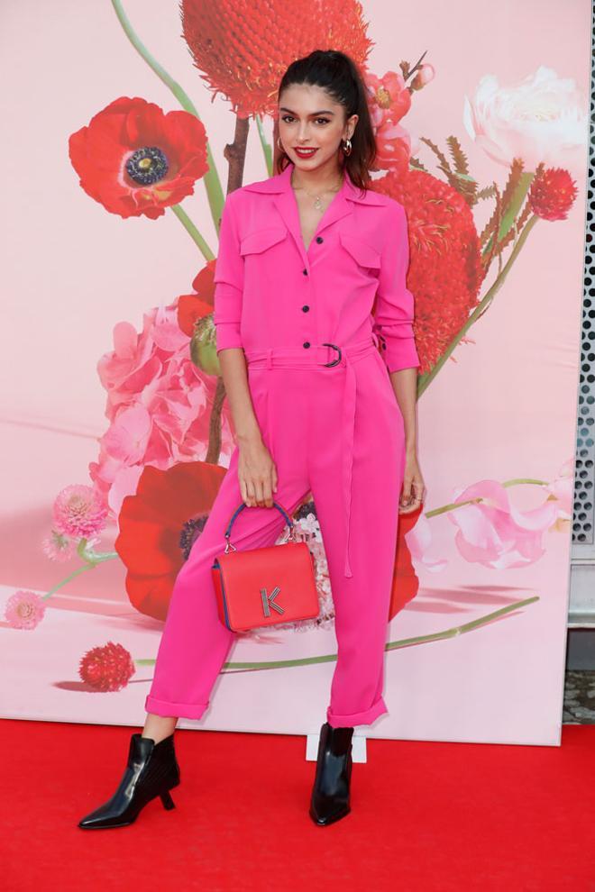 Lucía Rivera con mono fucsia y bolso rojo