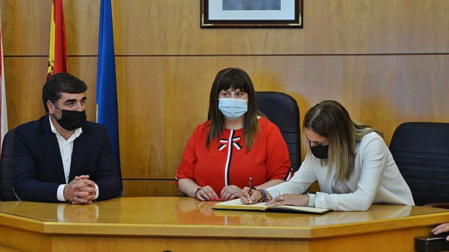 Nino Rodríguez, Amelia Fernández y Lucía Velasco, que firma en el libro del Ayuntamiento de Carreño. | B. G.