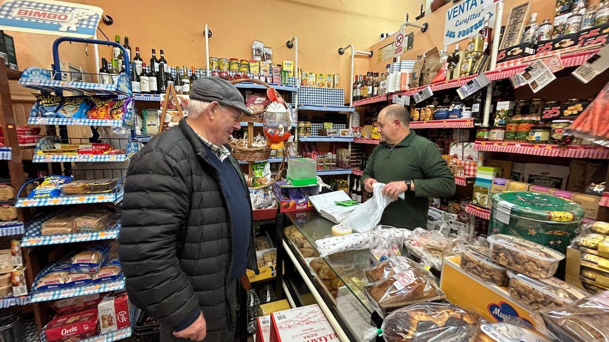 A la derecha, José Manuel Alba, propietario de La Tiendina de Jose, atendiendo a Baldomero Pérez.