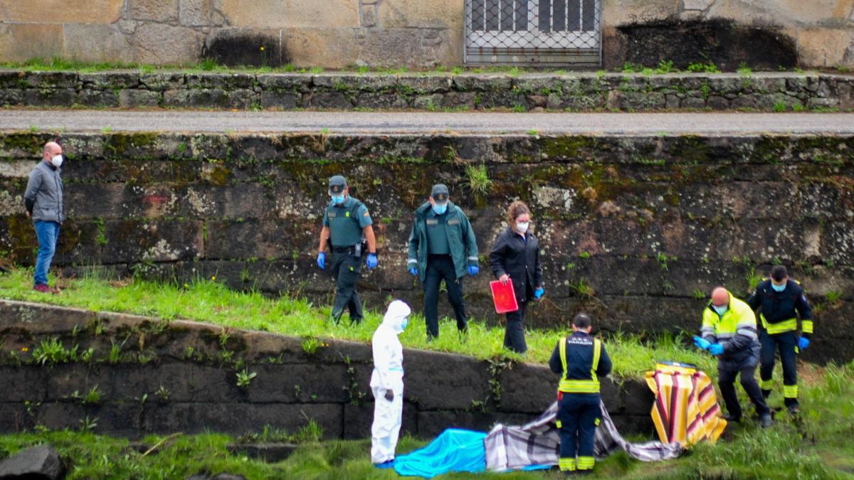 Efectivos de emergencias cubren el cuerpo aparecido en el Ulla. / I. Abella